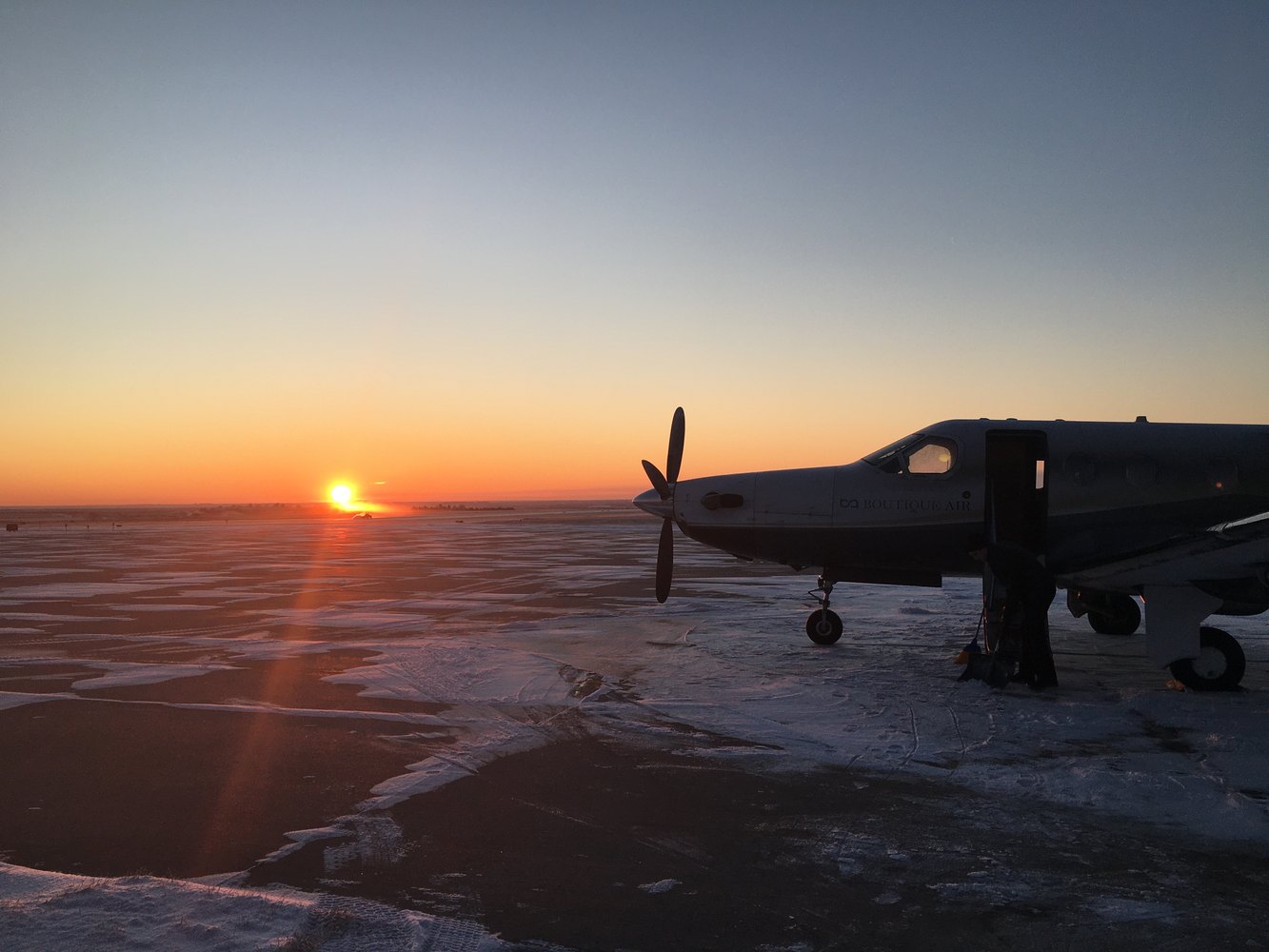 PC-12 on a snowy ramp at sunrise during winter operations
